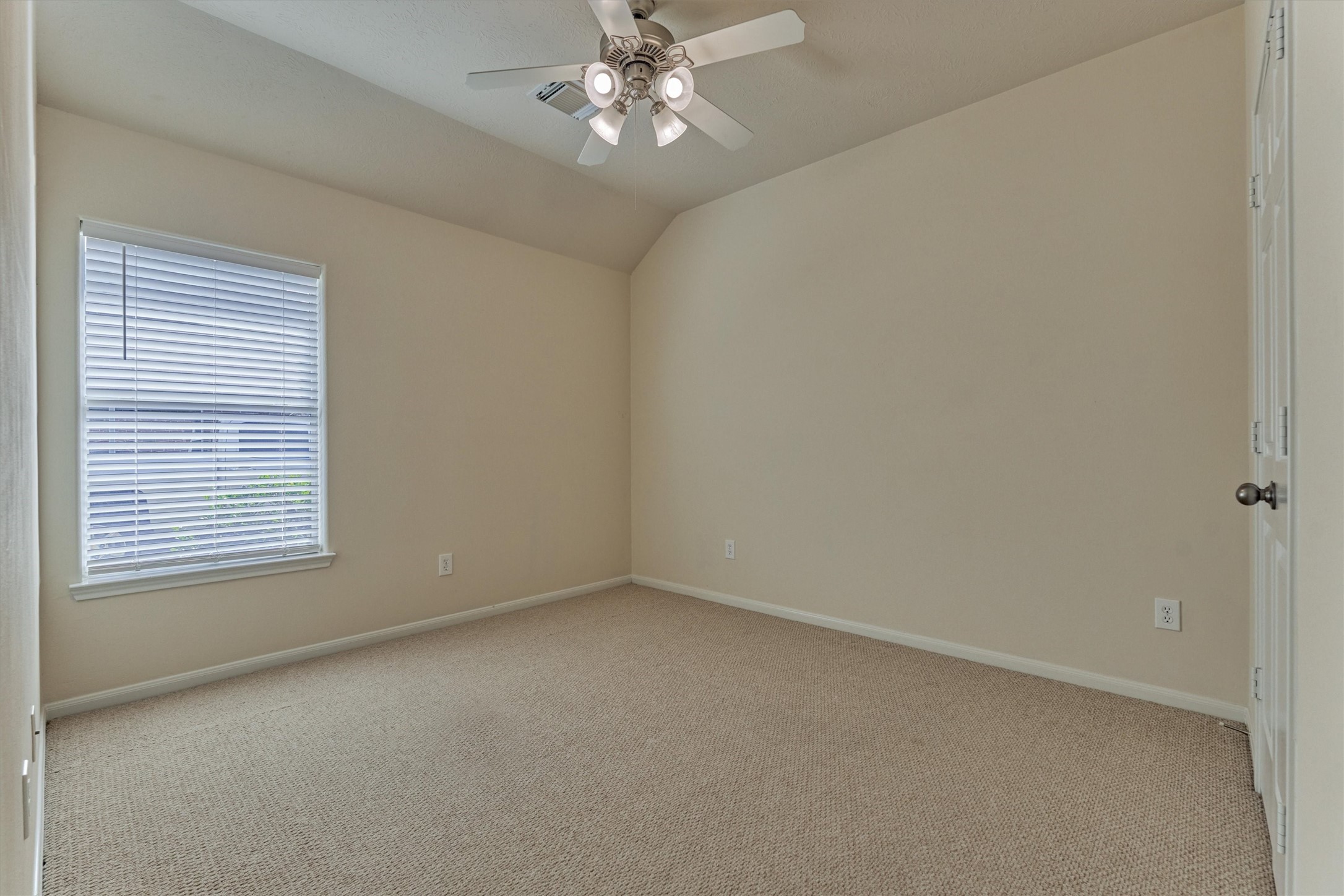 24910 Corbin Gate Drive Spring, TX 77389 - Photo 39 of 49 an empty room with a chandelier fan and windows