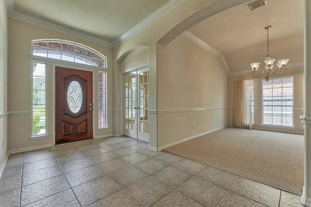 a view of an empty room with window and mirror
