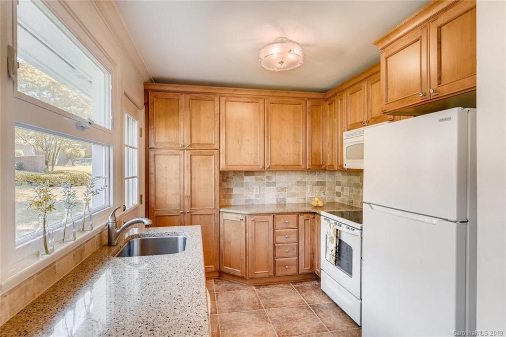 4214 Randolph Road Charlotte, NC 28211 - Photo 6 of 17 a kitchen with a refrigerator a stove top oven and a large window