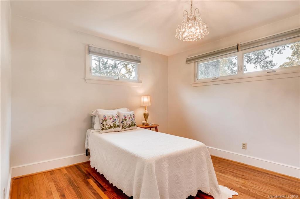 4214 Randolph Road Charlotte, NC 28211 - Photo 9 of 17 a bedroom with a bed and a chandelier