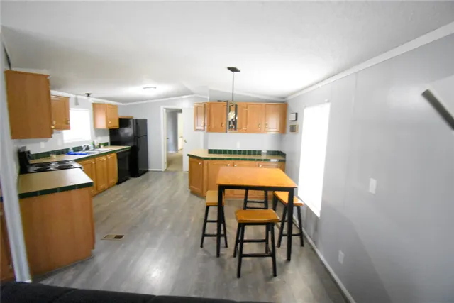 a kitchen with stainless steel appliances wooden floors dining table and chair