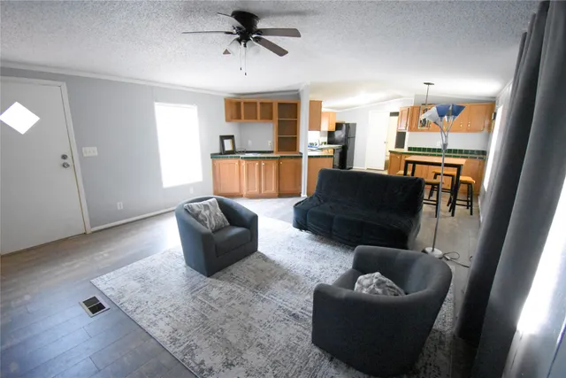 a living room with furniture and a view of kitchen