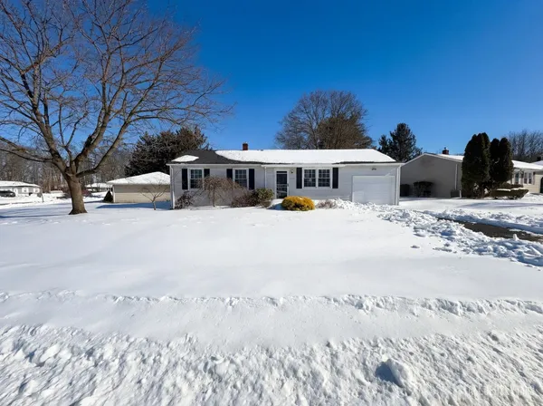 a view of a white house with a yard covered in snow