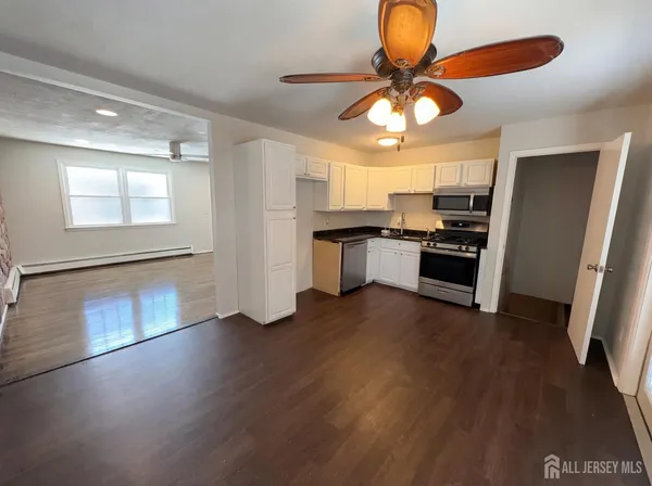 a kitchen with stainless steel appliances granite countertop a stove cabinets and wooden floor