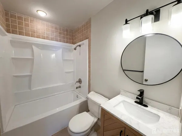 a bathroom with a sink toilet a mirror and bathtub