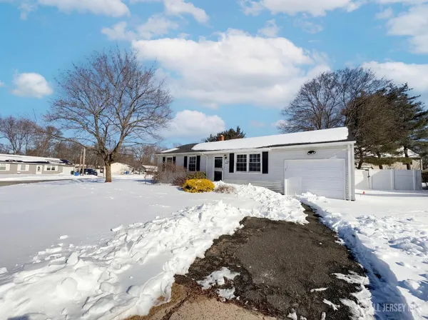 a view of a white house with a yard covered in snow