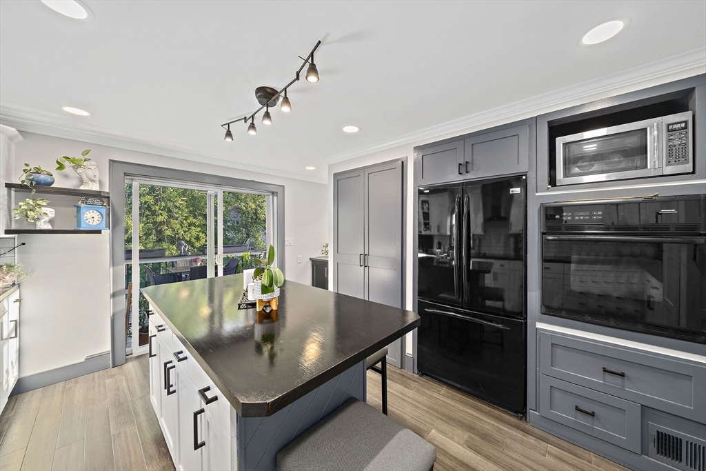 77 Botolph Street Quincy, MA 02171 - Photo 7 of 42 a kitchen with stainless steel appliances a dining table and stove top oven