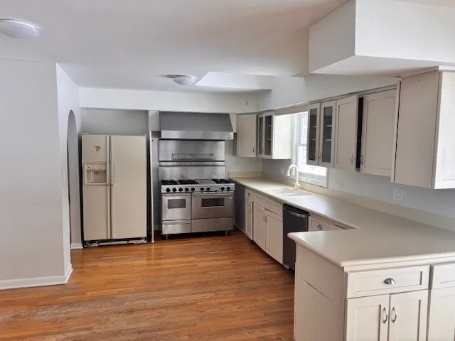 a kitchen with stainless steel appliances a sink a stove a refrigerator and cabinets