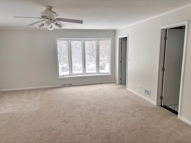a view of a big room with windows and chandelier fan