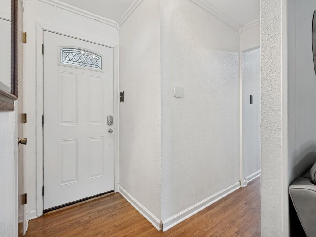 6484 Old Mill Circle Watauga, TX 76148 - Photo 3 of 25 Foyer entrance featuring a textured wall, ornamental molding, and wood finished floors