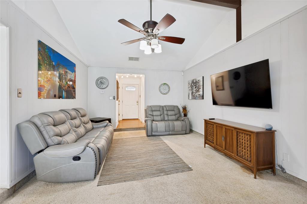 6484 Old Mill Circle Watauga, TX 76148 - Photo 7 of 25 Living room with a ceiling fan, light carpet, and vaulted ceiling