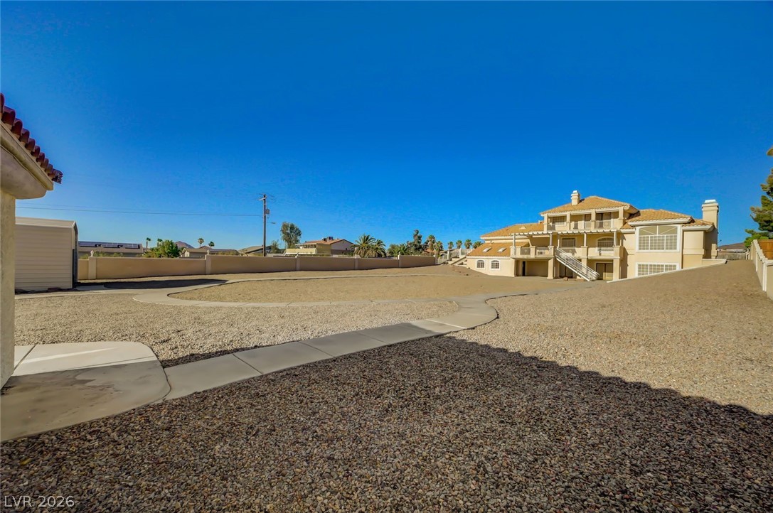 640 North Racetrack Road Henderson, NV 89015 - Photo 11 of 65 A desert oasis home, showcasing a multi-level architectural design with numerous balconies under a vast, clear sky.