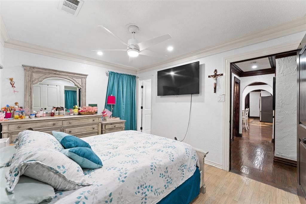 3318 San Marcus Avenue Dallas, TX 75228 - Photo 12 of 18 Bedroom featuring arched walkways, ornamental molding, light wood-style floors, a ceiling fan, and freestanding refrigerator