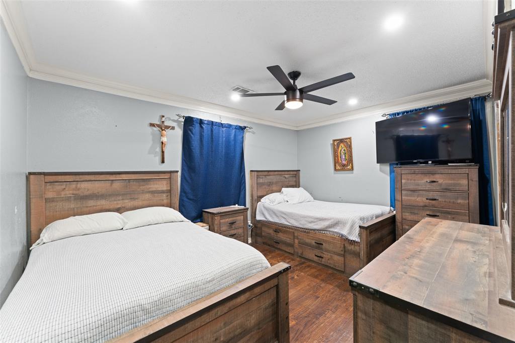 3318 San Marcus Avenue Dallas, TX 75228 - Photo 13 of 18 Bedroom featuring ornamental molding, a ceiling fan, and dark wood-style flooring