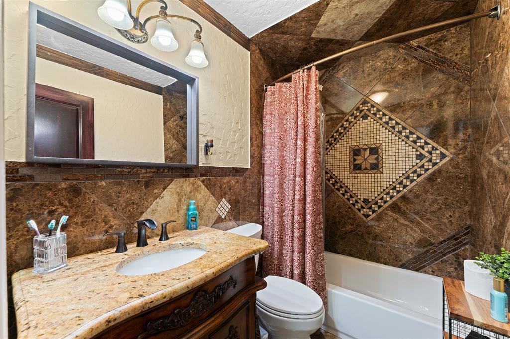 3318 San Marcus Avenue Dallas, TX 75228 - Photo 16 of 18 Full bathroom featuring vanity, shower / bathtub combination with curtain, tile walls, crown molding, and a textured wall