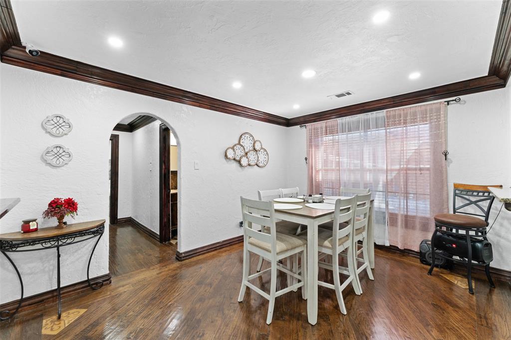 3318 San Marcus Avenue Dallas, TX 75228 - Photo 10 of 18 Dining room featuring arched walkways, crown molding, dark wood-type flooring, and a textured wall