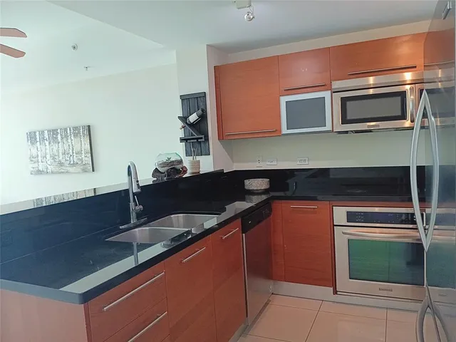 a kitchen with stainless steel appliances a sink stove and microwave
