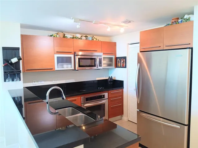 a kitchen with stainless steel appliances a refrigerator sink and stove