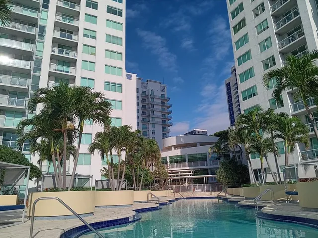 a view of swimming pool with outdoor seating and house in the background