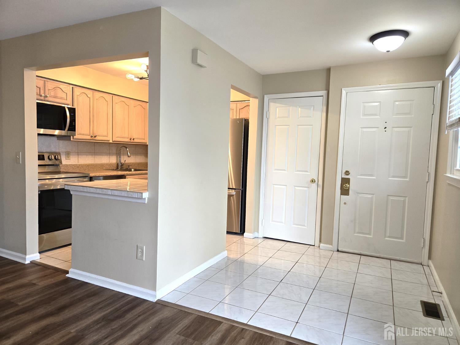 49 Alexandria Way Bernards, NJ 07920 - Photo 4 of 14 a view of a kitchen with a refrigerator wooden floor and a kitchen