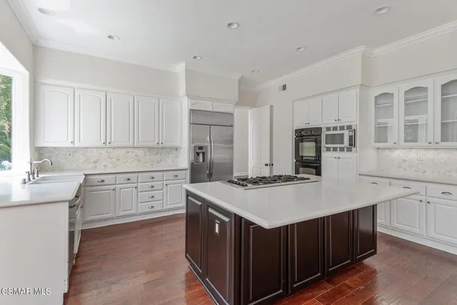 a kitchen with a stove a sink a refrigerator and cabinets