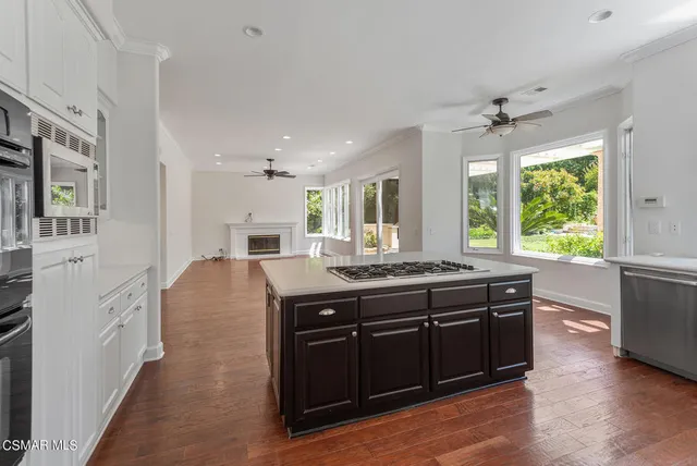 a large kitchen with stainless steel appliances granite countertop a stove and a wooden floors