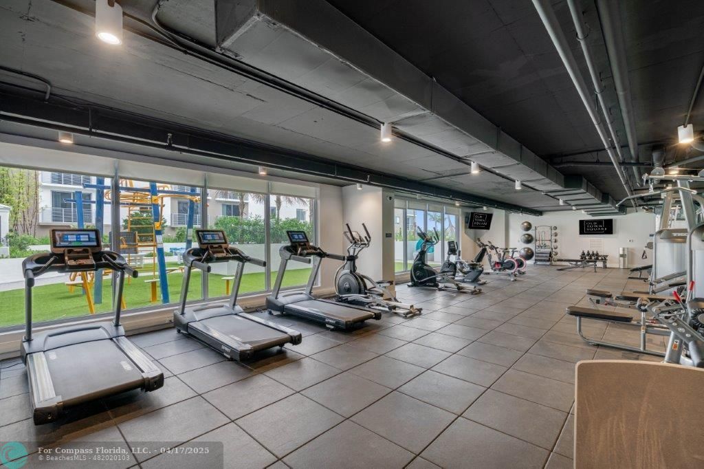 200 Northeast 1st Avenue, Unit 1027 Pompano Beach, FL 33060 - Photo 13 of 18 a view of a room with gym equipment and a large window