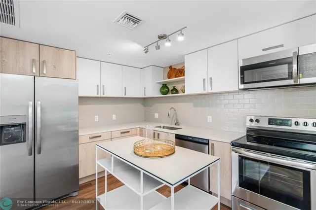 a kitchen with stainless steel appliances a stove a sink a microwave and cabinets