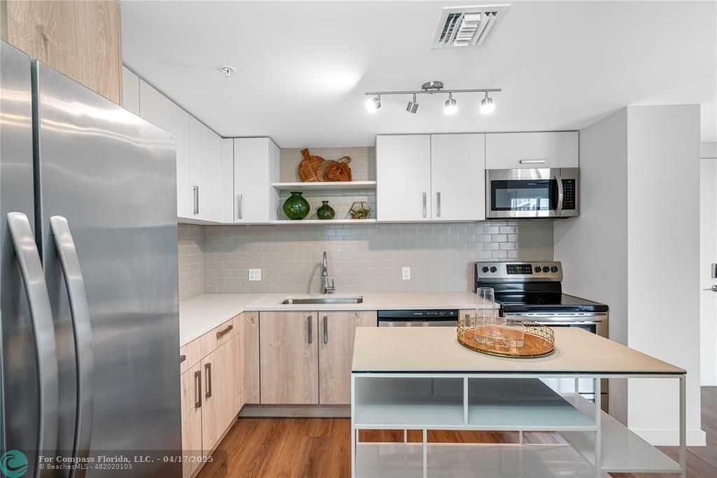 200 Northeast 1st Avenue, Unit 1027 Pompano Beach, FL 33060 - Photo 9 of 18 a kitchen with stainless steel appliances granite countertop a refrigerator a stove top oven a sink and dishwasher