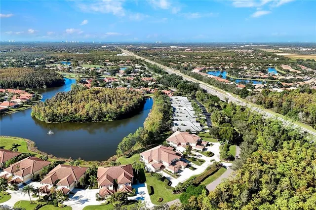 an aerial view of ocean and residential houses with outdoor space