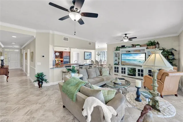a living room with furniture kitchen view and a chandelier