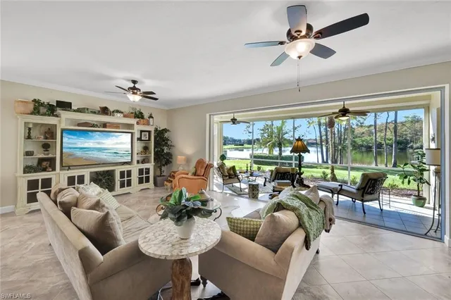 a living room with furniture ceiling fan and a large window