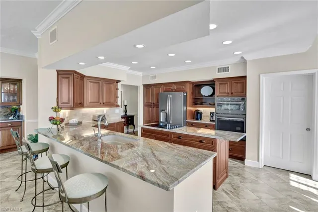 a large kitchen with stainless steel appliances granite countertop a large counter top and a stove