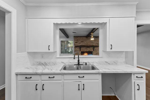 a kitchen with granite countertop a sink stainless steel appliances and cabinets