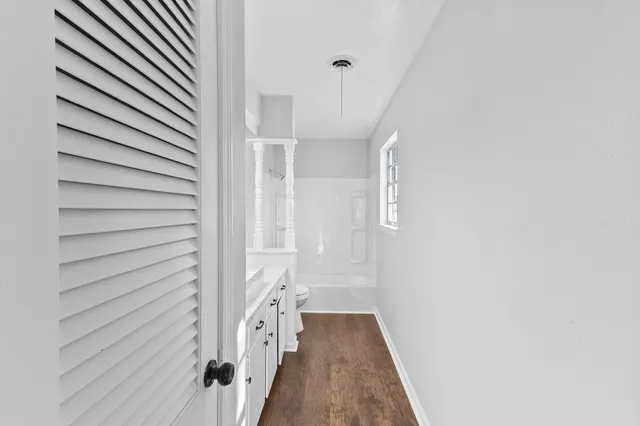 a view of a hallway with wooden floor and staircase