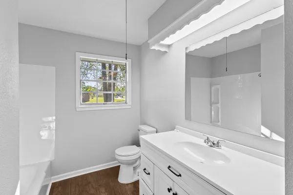 a bathroom with a sink a toilet and a window