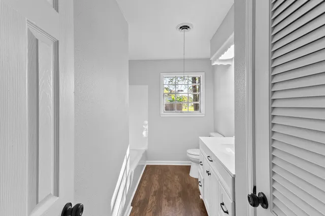 a bathroom with a sink a toilet and a window