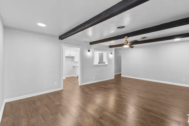 a view of empty room with wooden floor