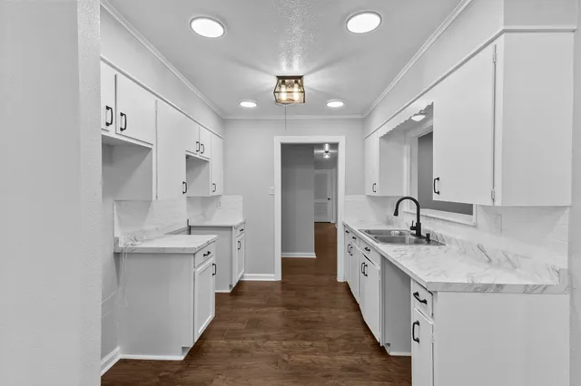 a large kitchen with a sink and dishwasher stove a refrigerator a sink dishwasher with wooden floor