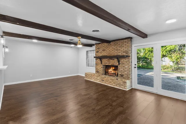 a view of empty room with wooden floor and fireplace