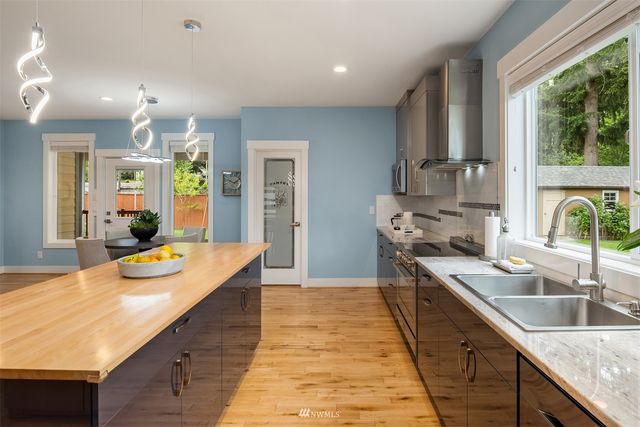 a large kitchen with kitchen island a large window in it