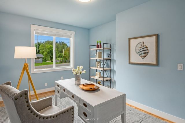a view of a workspace with furniture and a window