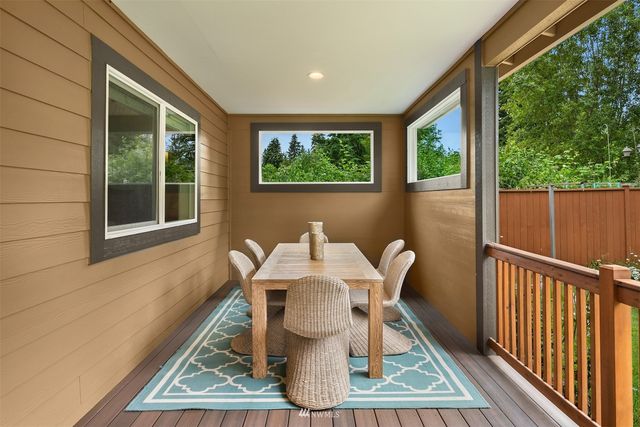 a view of a patio with table and chairs with wooden floor and fence