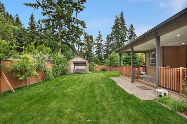 a view of a backyard with table and chairs and a tree