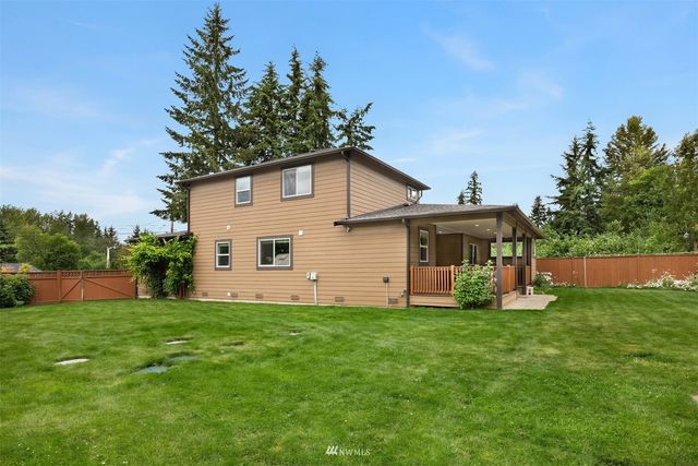 a view of a house with a yard and sitting area