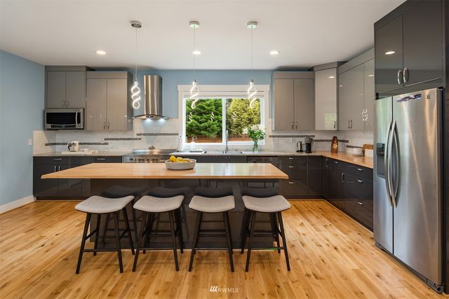 a kitchen with a table chairs sink and cabinets