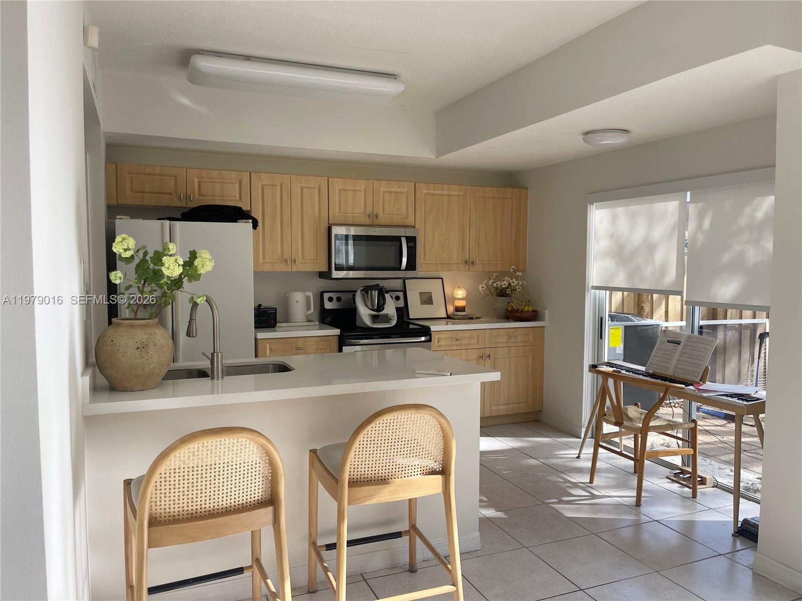 10160 Southwest 88th Street, Unit 201 Miami, FL 33176 - Photo 12 of 43 a kitchen with stainless steel appliances granite countertop a table and chairs in it