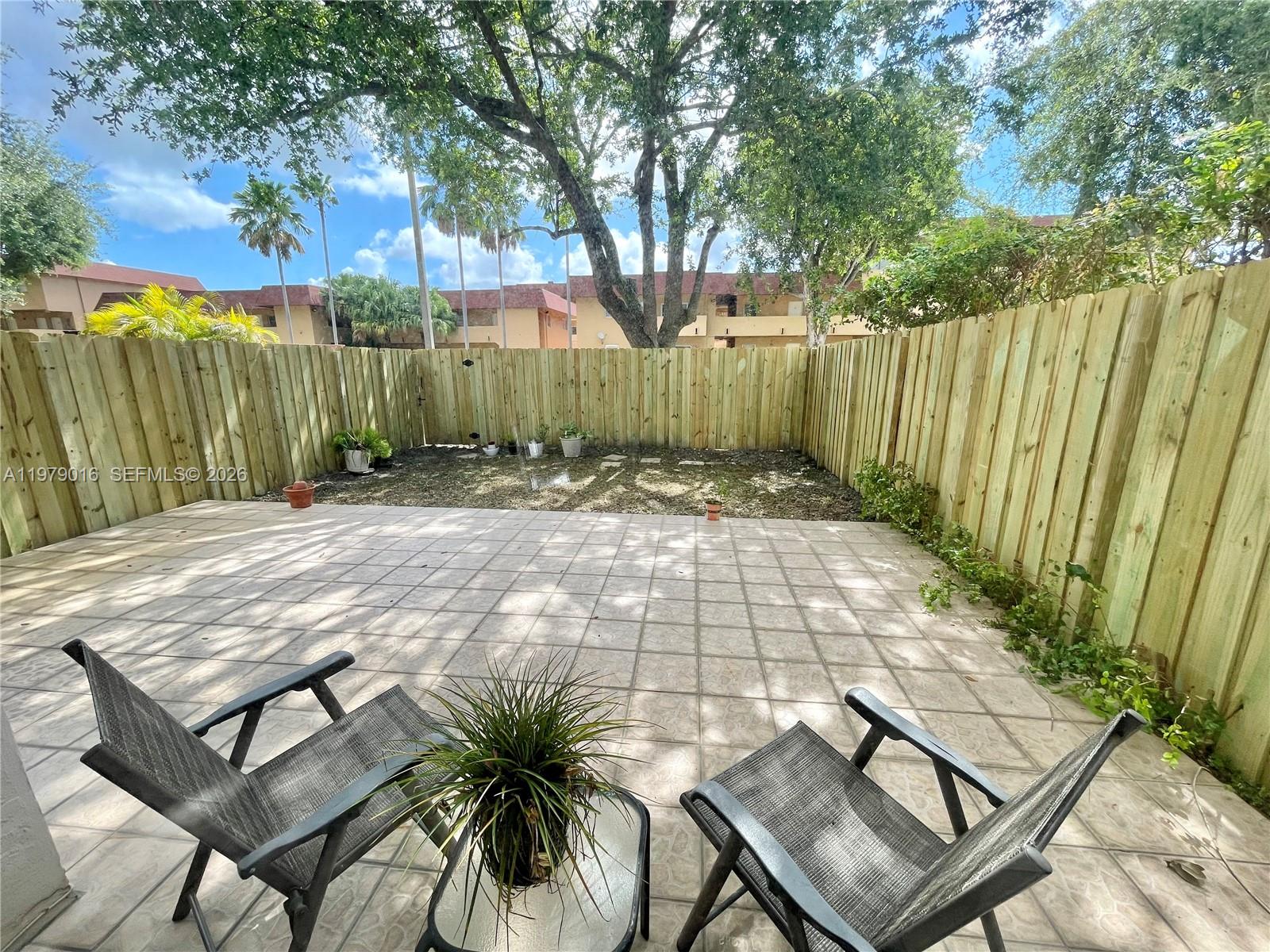 10160 Southwest 88th Street, Unit 201 Miami, FL 33176 - Photo 9 of 43 a backyard of a house with table and chairs