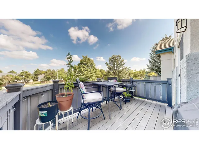 a balcony with chairs and a dining table with wooden floor