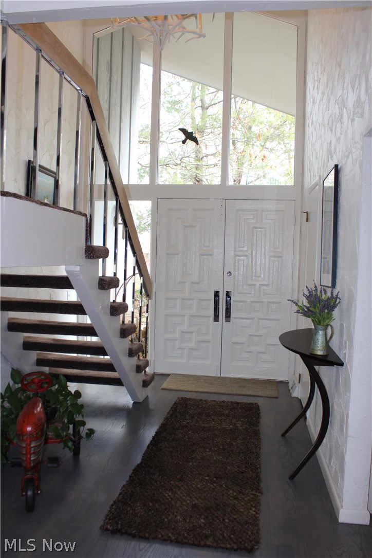 Dramatic, two story entry with hardwood floors, organic railing, metal and wood make for this very inviting foyer.